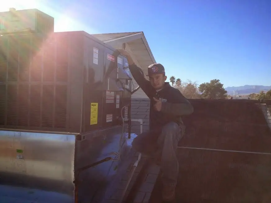 HVAC technician performing Air Duct Repair on a rooftop unit in Greenbrier